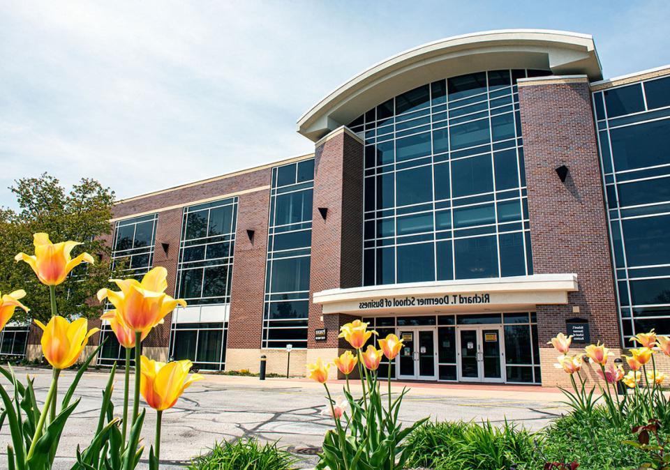 Exterior of the Doermer School of Business Building with flowers in the foreground.